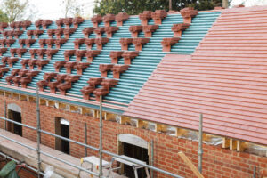 A new roof is installed in the UK with plain red clay tiles