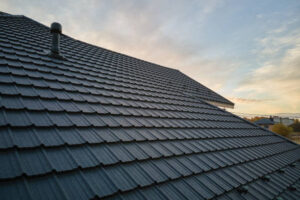 Closeup of house roof top covered with ceramic shingles. Tiled covering of building.